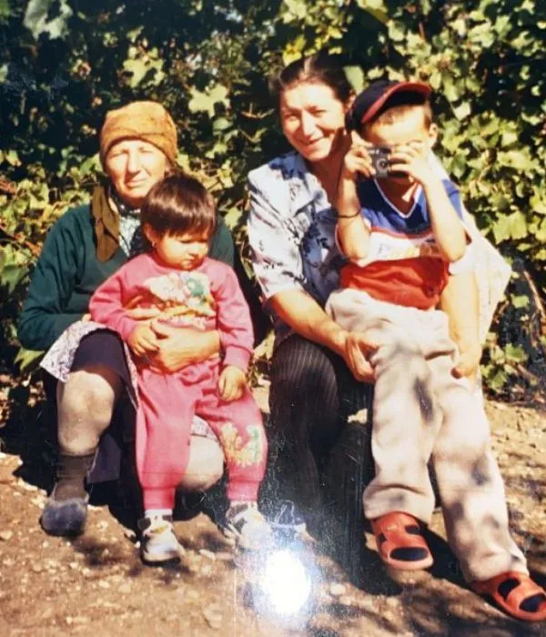 Fotografie de familie din arhiva personală, afară sub vița-de-vie: George Pantelimon, copil, fotografiind cu un aparat mic